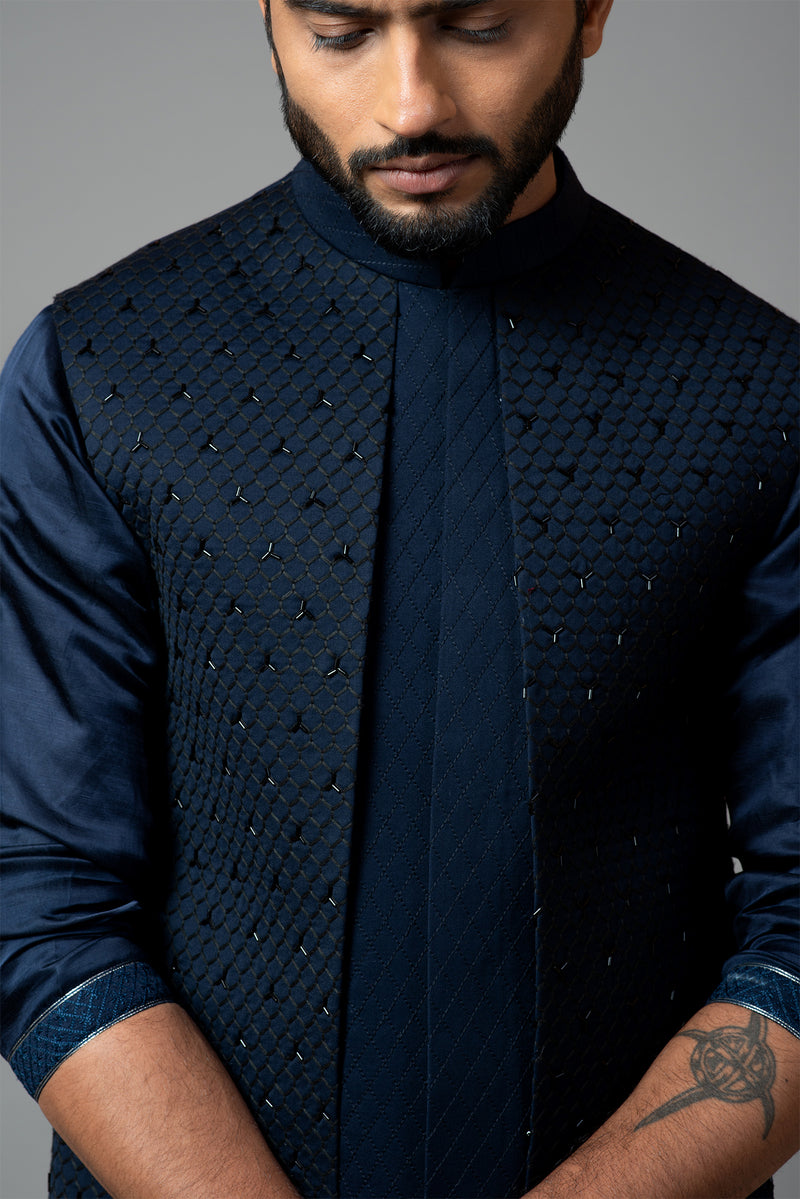Navy blue Nehru jacket with Honeycomb pattern embroidery highlighted with panel detailing, paired with adrape kurta set