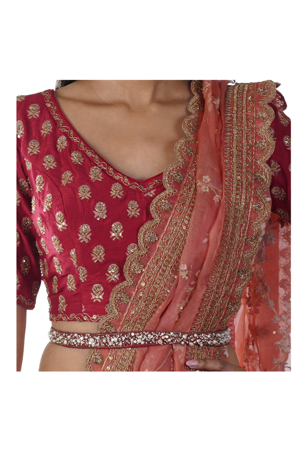 Rust Red Hand Embroidered Blouse with a Peach Lehenga paired with a Heavily Embroidered Dupatta